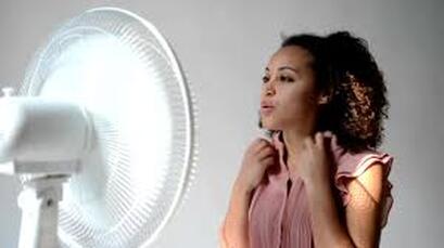 Woman cooling off with fan